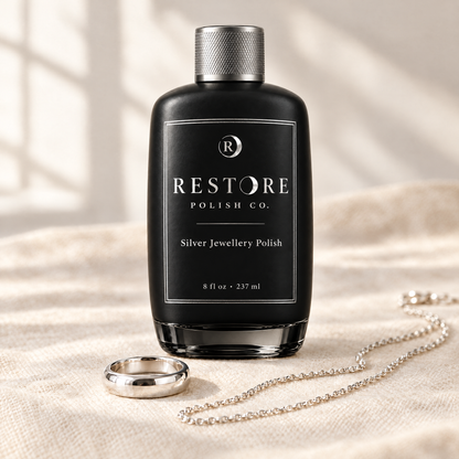 Restore Kit: Restore polish bottle with a polished silver ring and chain on linen